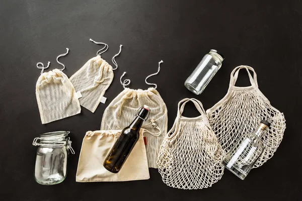 廃棄物ゼロ再利用可能なショッピングキット 綿生地の袋 ガラス瓶や瓶 エコロジー 上からのプラスチックフリーライフスタイルの概念 トップビュー フラットレイアウト 黒の背景 フリーコピースペース — ストック写真