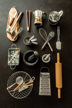 Siyah karatahta arka planında mutfak aletleri (pişirme aletleri). Yukarıdan alınan mutfak gereçleri koleksiyonu (üst görünüm, düz konum).