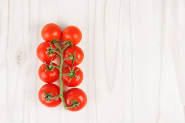 Olgun kırmızı domates dalında Beyaz ahşap yüzey üzerinde. Üstten Görünüm.