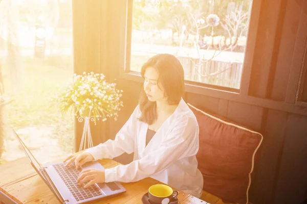 Bir Asyalı kız yazarak ve dizüstü klavye için seyir 