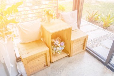 Ahşap masa ahşap tabure ve çiçek vazo ile iki yastık