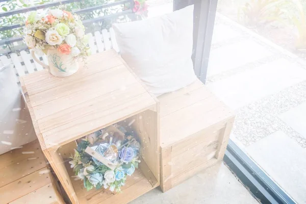 Ahşap masa ahşap tabure ve çiçek vazo ile iki yastık