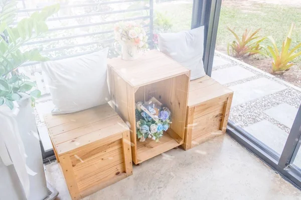 Ahşap masa ahşap tabure ve çiçek vazo ile iki yastık