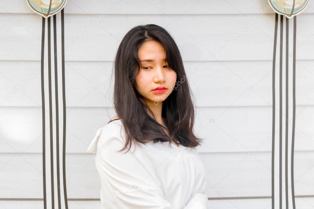 Asian girl in white cloth with damaged hair and looking sad.