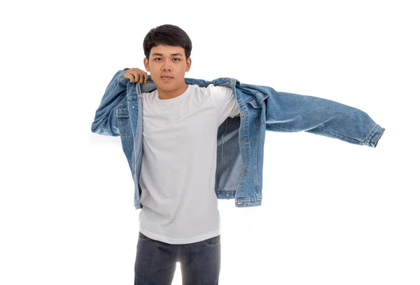 Siyah saçlı Asyalı bir çocuk stüdyoda beyaz gömlek ve kot ceket giyiyor..