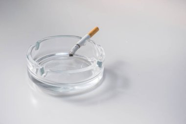 Kül tablası beyaz arka plan üzerinde sigara yakma ek yük