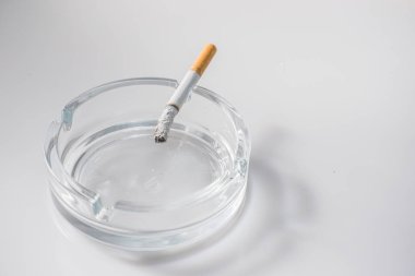 Kül tablası beyaz arka plan üzerinde sigara yakma ek yük