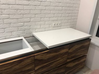 Dikey çekim. Adam mutfakta bir bardak şarapla dinleniyor. Akıllı telefon kullanıyor.