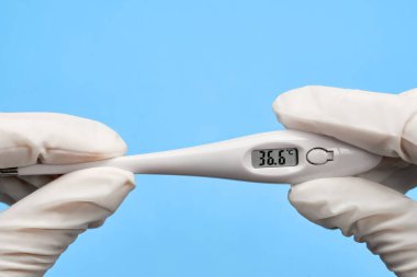 Mavi arka planda tıbbi termometre var..