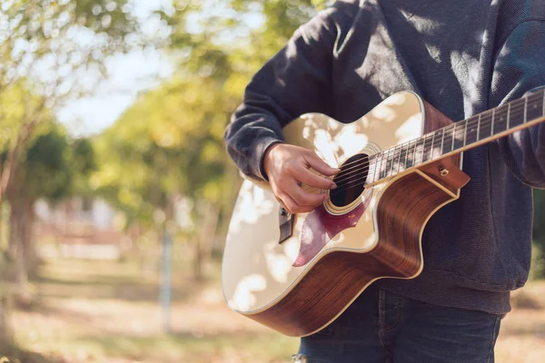 Man playing an acoustic guitar in the park, Close-up — Stock Photo, Image