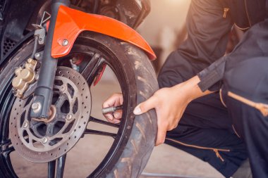 Motosiklet tamir servisi, tamirci lastiği pompalıyor, yakın plan..
