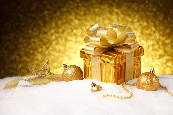 Caja de regalo de oro de Navidad con bolas y decoración en la nieve —  Fotos de Stock