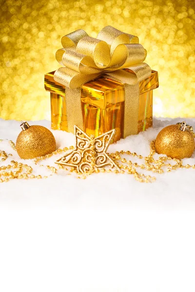 Caja de regalo de oro de Navidad con bolas y decoración en la nieve Imagen de stock