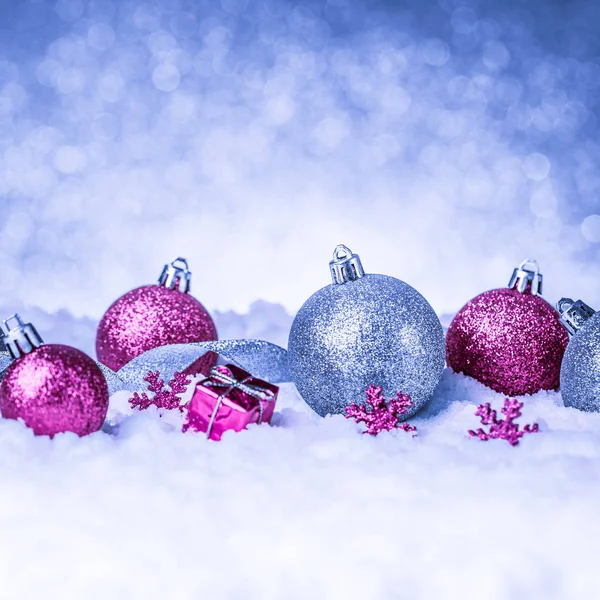 Christmas ornament in snow on glitter background — Stock Photo, Image