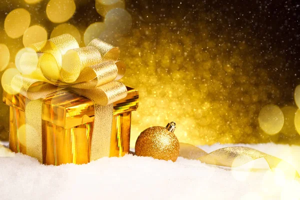 Caixa de presente de ouro de Natal com bolas e decoração na neve — Fotografia de Stock
