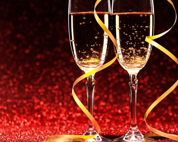 Glasses of champagne with yellow holidays ribbons — Stock Photo, Image