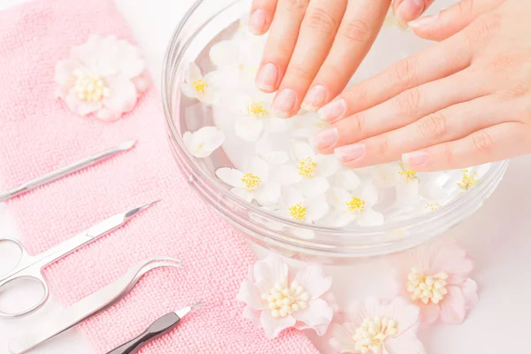 Hermosas manos de mujer con manicura en tazón de agua —  Fotos de Stock