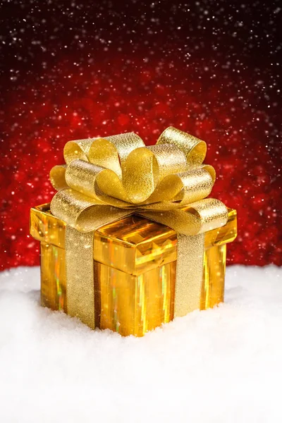 Caja de regalo de Navidad con arco de pie en la nieve —  Fotos de Stock