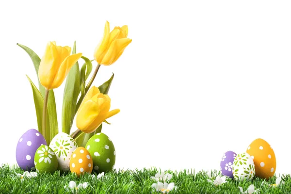 Huevos de Pascua escondidos en la hierba con tulipanes —  Fotos de Stock