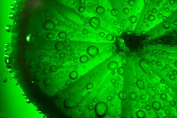Лайм с пузырьками на зеленом фоне — стоковое фото