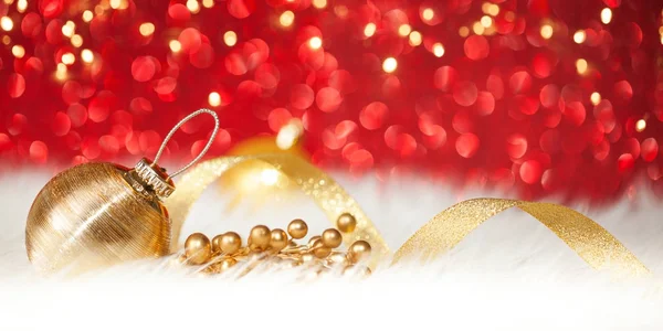Natal bola de ouro no fundo brilho vermelho — Fotografia de Stock