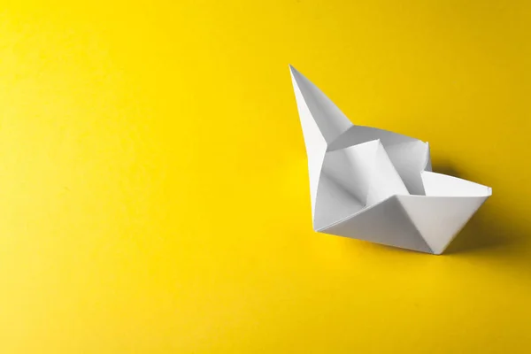 Origami de papel de barco no fundo amarelo — Fotografia de Stock