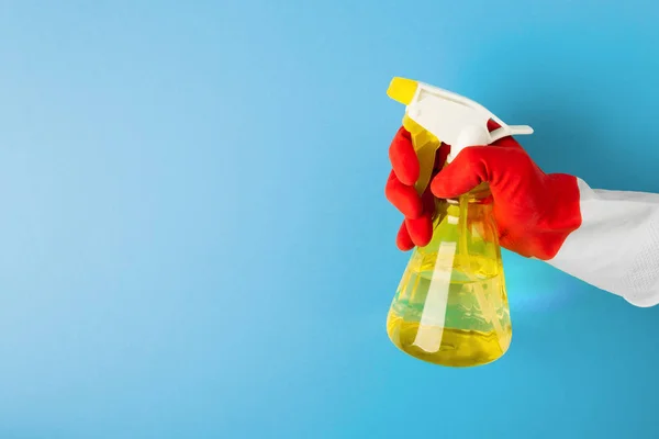 En hand i en röd handske innehar en spray med rengöringsvätska — Stockfoto