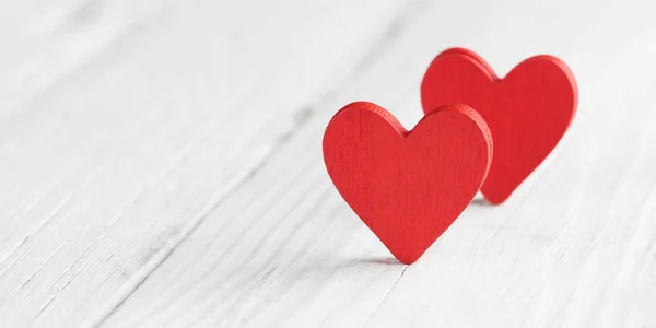 Dos corazones rojos sobre fondo de madera, primer plano — Foto de Stock
