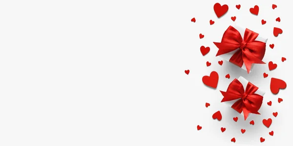 Composição do dia dos namorados: caixas de presente brancas e arcos vermelhos e corações de feltro vermelho — Fotografia de Stock