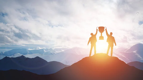 Silhouette man holding up a gold trophy cup. — Stock Photo, Image