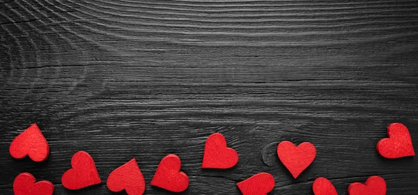 Червоні дерев'яні серця на темному дерев'яному столі з копіспасом . — стокове фото