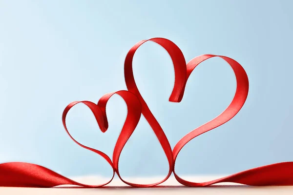 Ribbon shaped as hearts on blue background — 图库照片