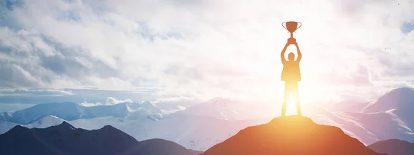 Silueta de un hombre sosteniendo un trofeo al atardecer — Foto de Stock