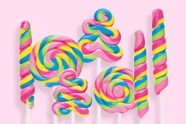 Colored lollipops of different shapes on a pink background — Stock Photo, Image