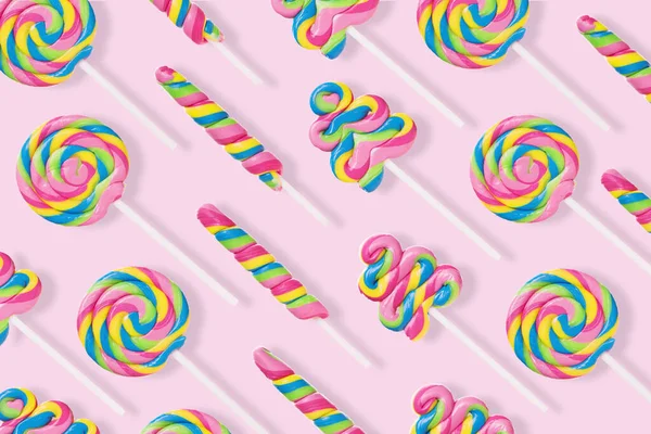 Patrón hecho con caramelos de colores sobre fondo rosa . — Foto de Stock