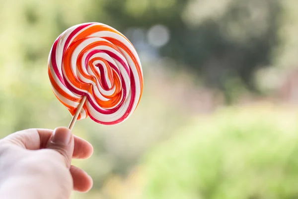 Handen håller lollipop godis — Stockfoto