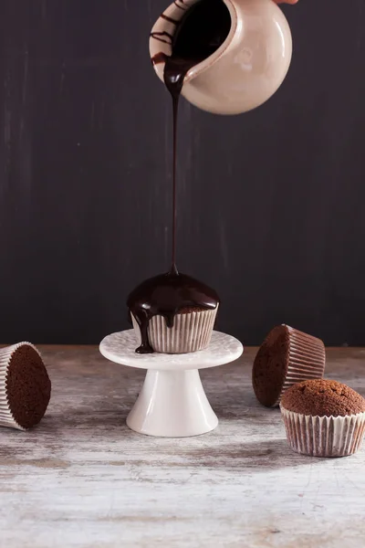 Chocolate muffin with pouring chocolate sauce — Stock Photo, Image