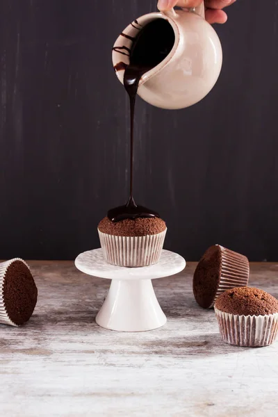 Chocolate muffin with pouring chocolate sauce — Stock Photo, Image