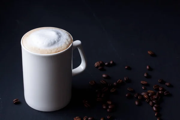 A mug of latte coffee on a black background — Stock Photo, Image