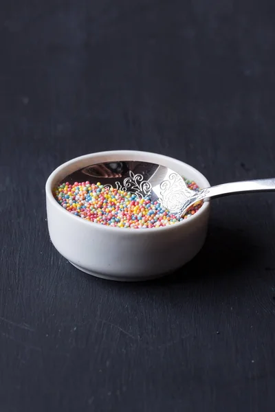 Sugar sprinkles on a black background — Stock Photo, Image