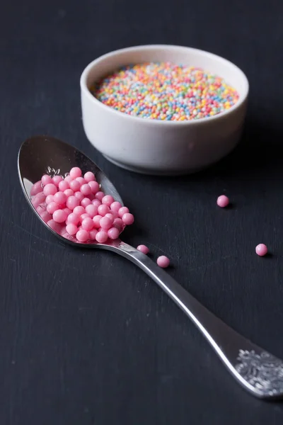 Sugar sprinkles on a black background — Stock Photo, Image