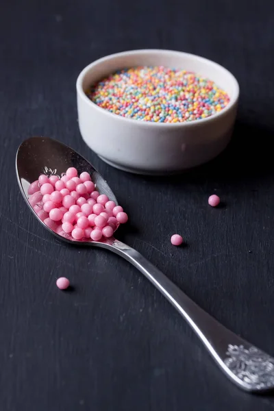 Sugar sprinkles on a black background — Stock Photo, Image