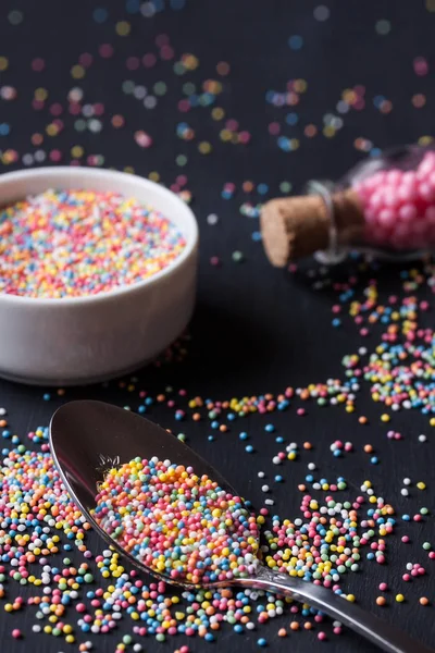 Sugar sprinkles on a black background — Stock Photo, Image