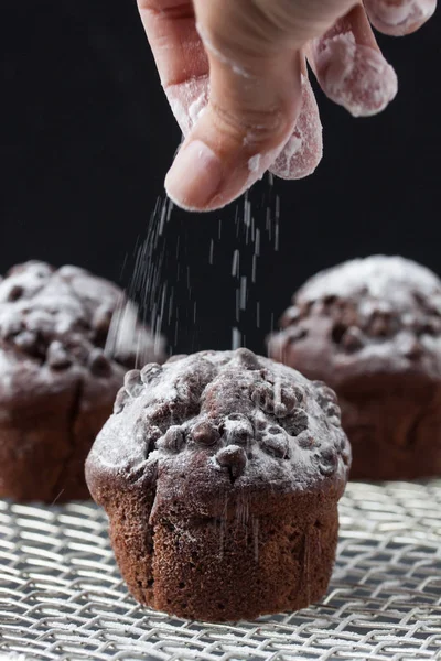 Chocolate muffin,  pouring powdered sugar — Stock Photo, Image