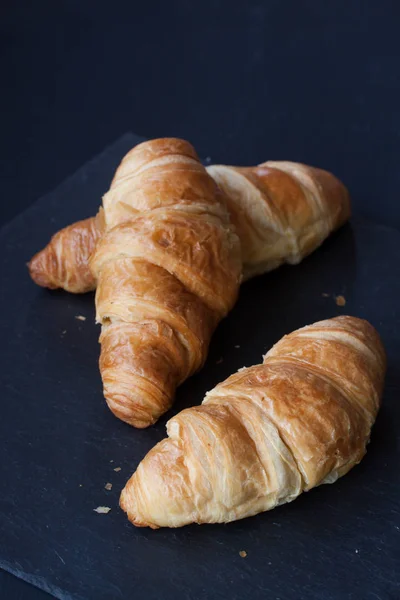 Croissant broodje op een zwarte achtergrond — Stockfoto