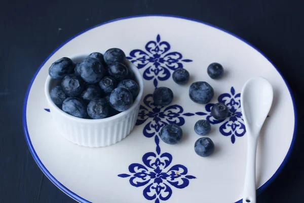 Blueberry in a plate on a black background — Stock Photo, Image