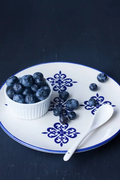 Blueberry in a plate on a black background — Stock Photo, Image