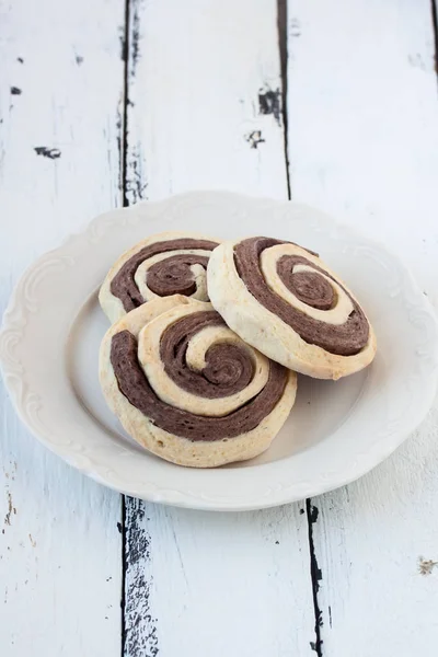 Biscoitos espirais em um fundo de madeira branco — Fotografia de Stock