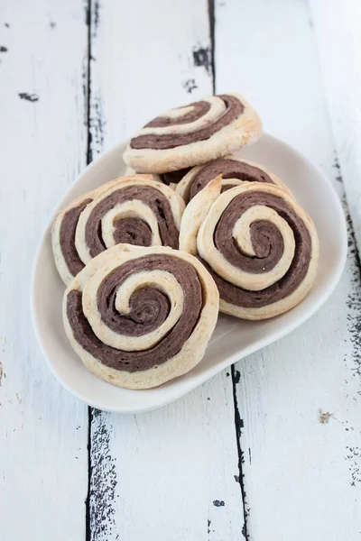 Biscoitos espirais em um fundo de madeira branco — Fotografia de Stock