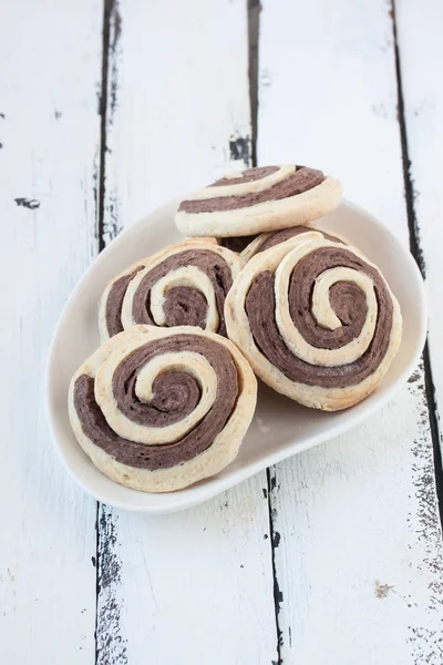 Biscoitos espirais em um fundo de madeira branco — Fotografia de Stock